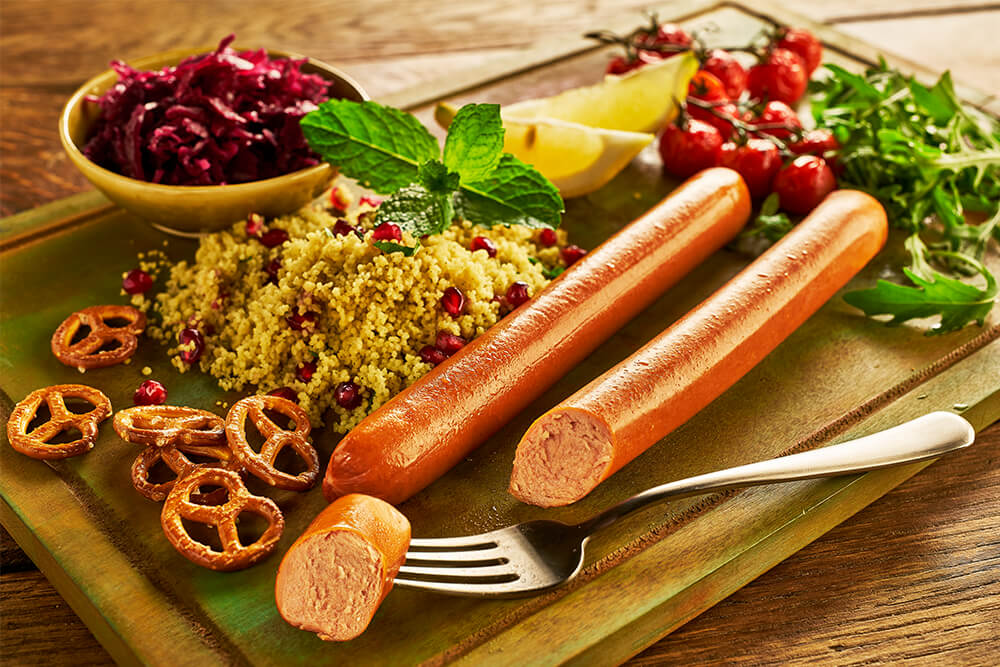 Bratwurst sausage on wooden board with potatoes and mustard on the side