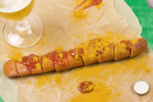 A VW Volkswagen Currywurst with ketchup and curry-powder and a glass of beer